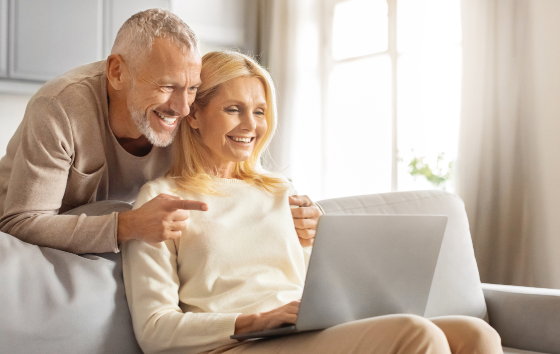 A couple looking on their laptop together, smiling
