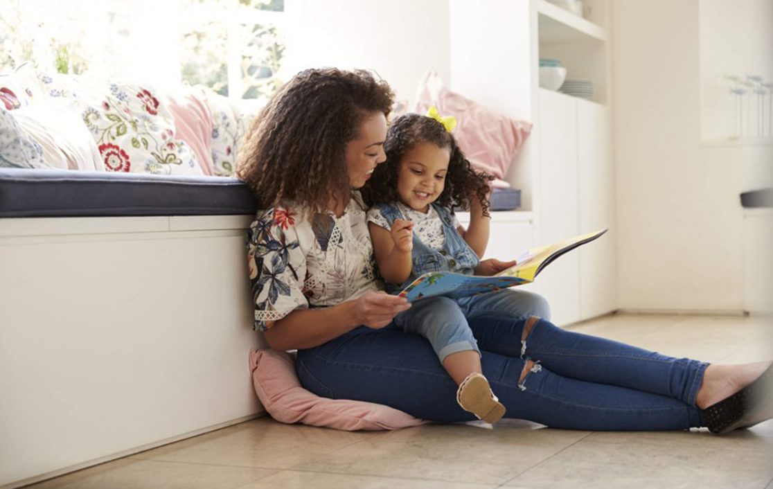 A mother and her daughter sat together reading a book