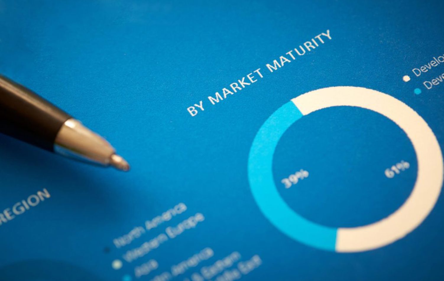 A pen laying atop of a form displaying charts and figures